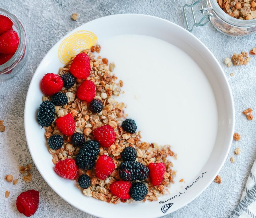 Bowl of Greek yogurt topped with granola, raspberries, and blackberries